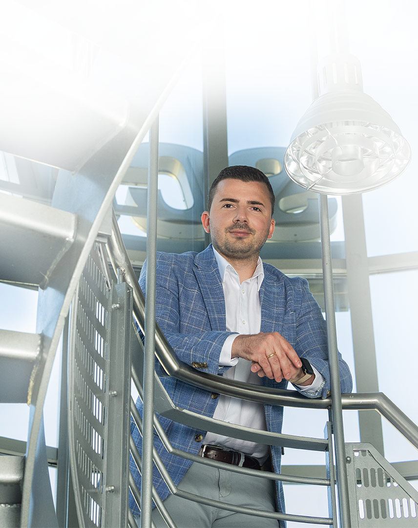 Bild von Marco Calanni vor einer großen Fensterwand